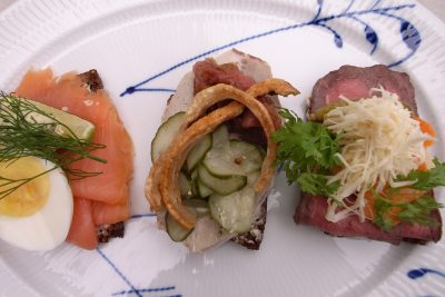 Open-faced sandwiches with cured meats and fresh vegetables.