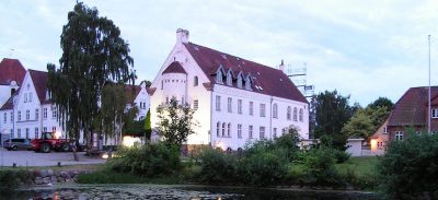 Two grand, old-style white building stand next to one another.