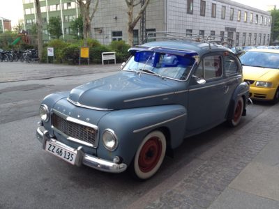 An old blue Volvo automobile parked on a street.